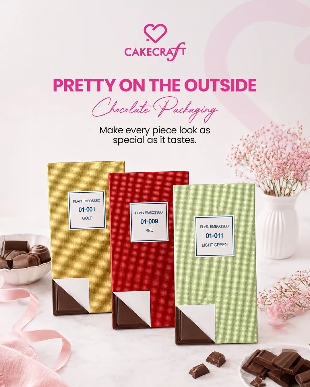 Three chocolate bars in gold, red and green sleeves among pink flowers, under the words Pretty on the outside