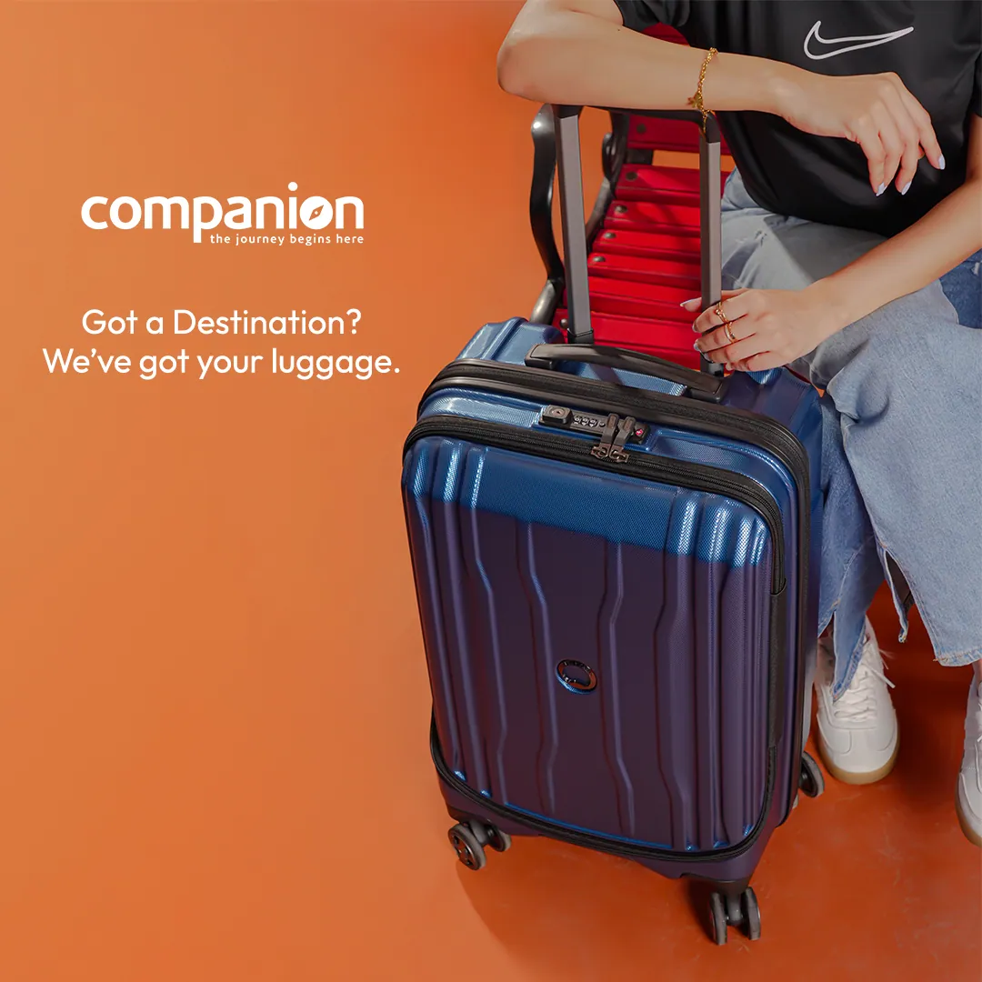 Ad: a navy cabin suitcase with a red bag on its handle, beside a seated person in jeans, with the words Got a destination? We've got your luggage