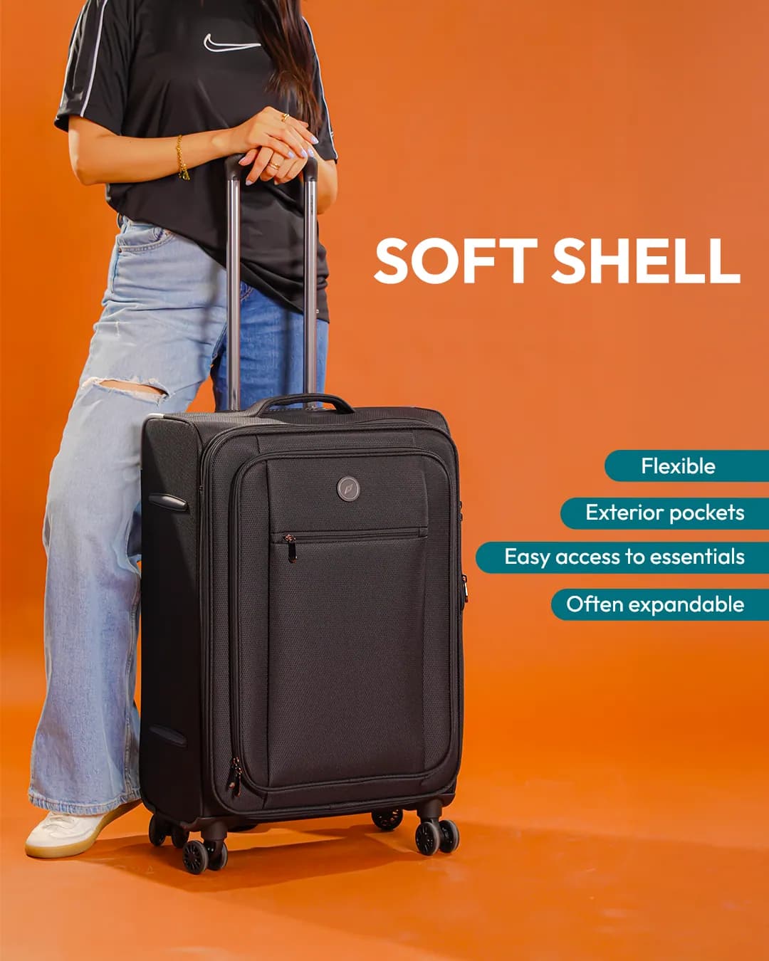 A black soft-shell suitcase held by a person in jeans, shown from the shoulders down, on orange, with its features listed