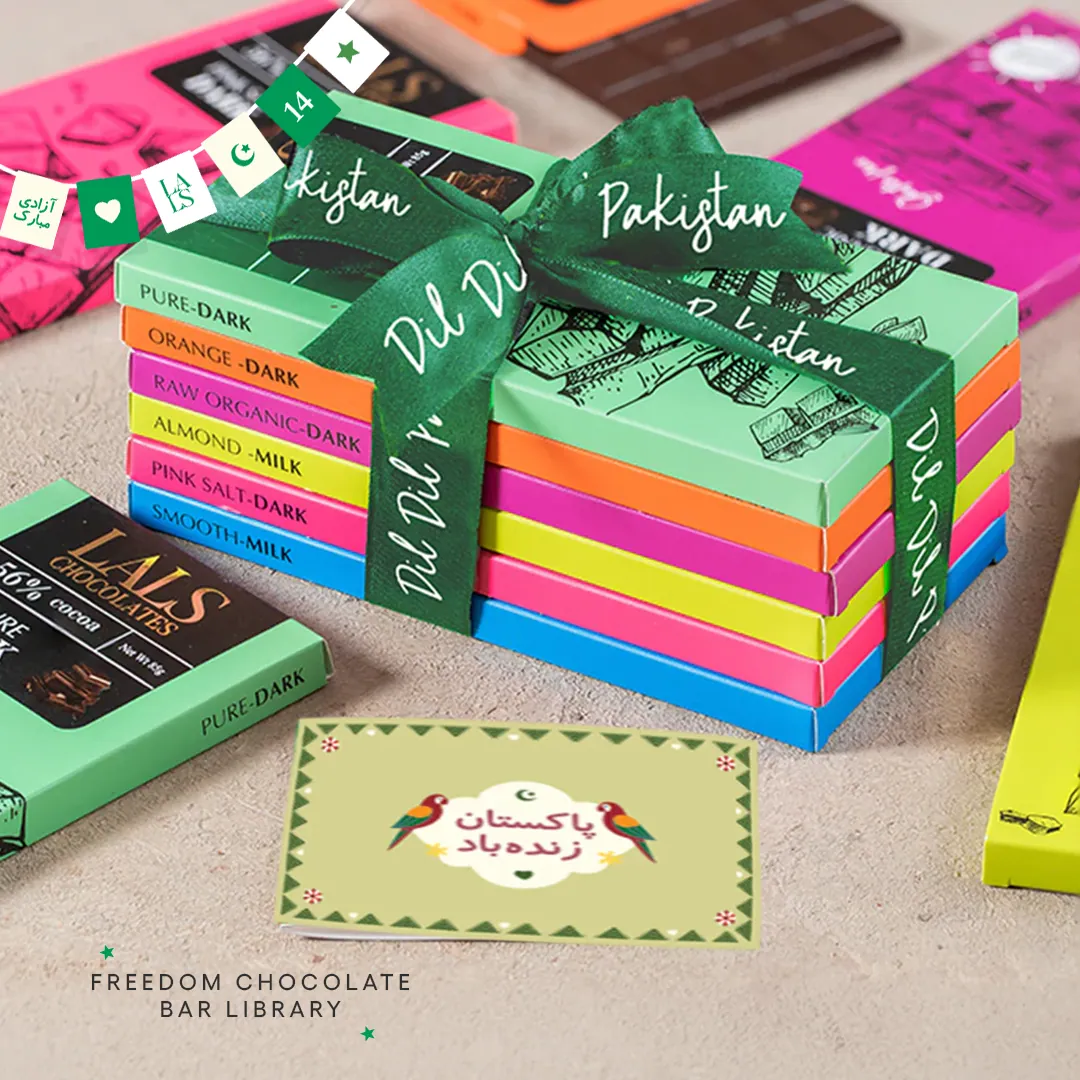 A stack of Lals chocolate bars in bright wrappers, tied with a green Pakistan ribbon, beside a card