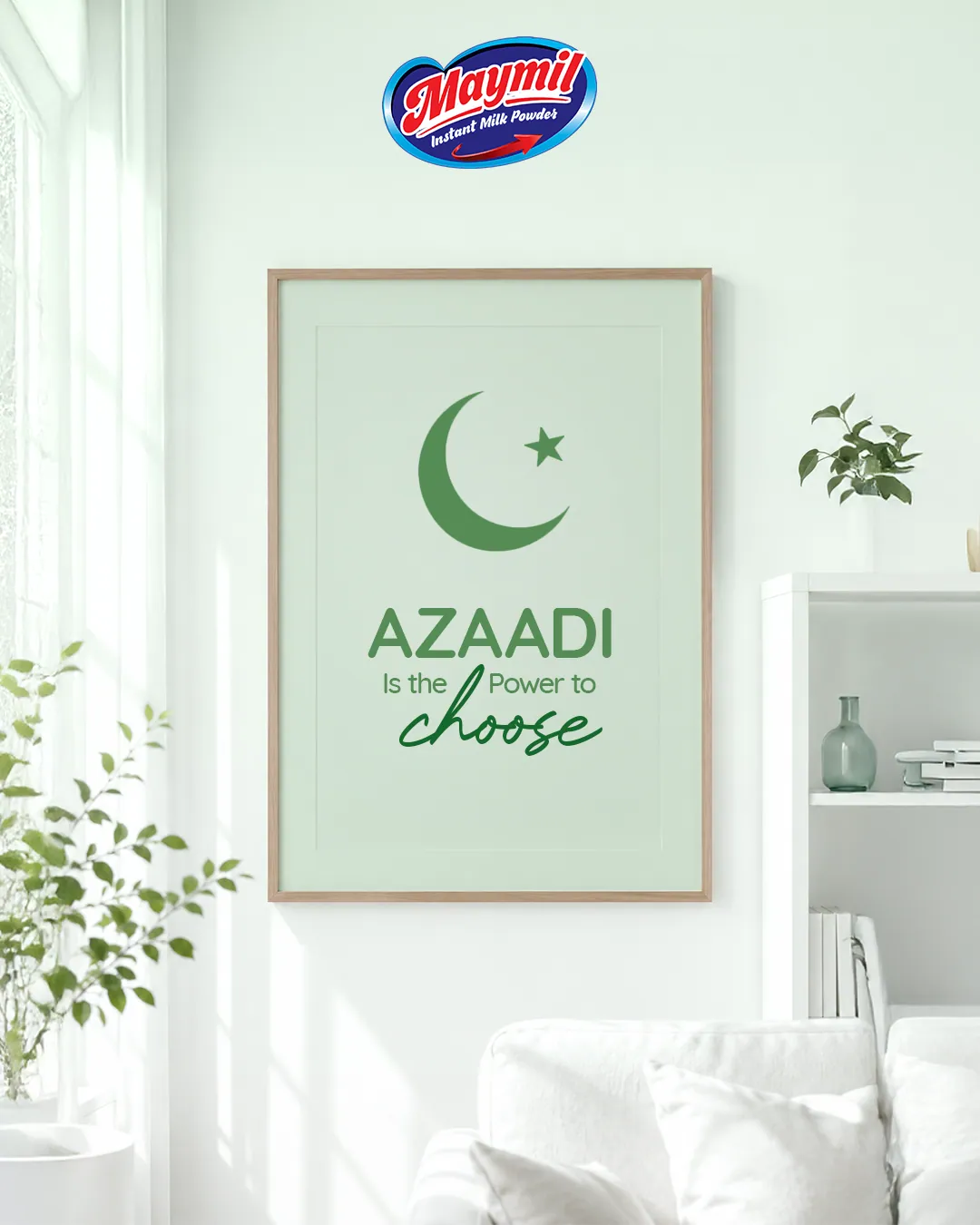 A framed print reading Azaadi is the power to choose, on a pale wall with plants, under the Maymil logo