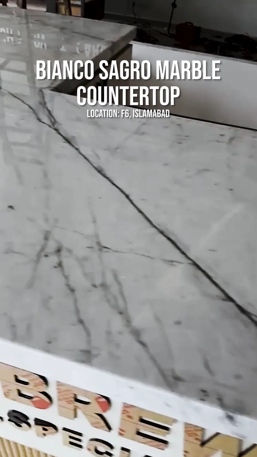 Still from a reel: a white marble countertop with grey veins, with the words Bianco Sagro marble countertop